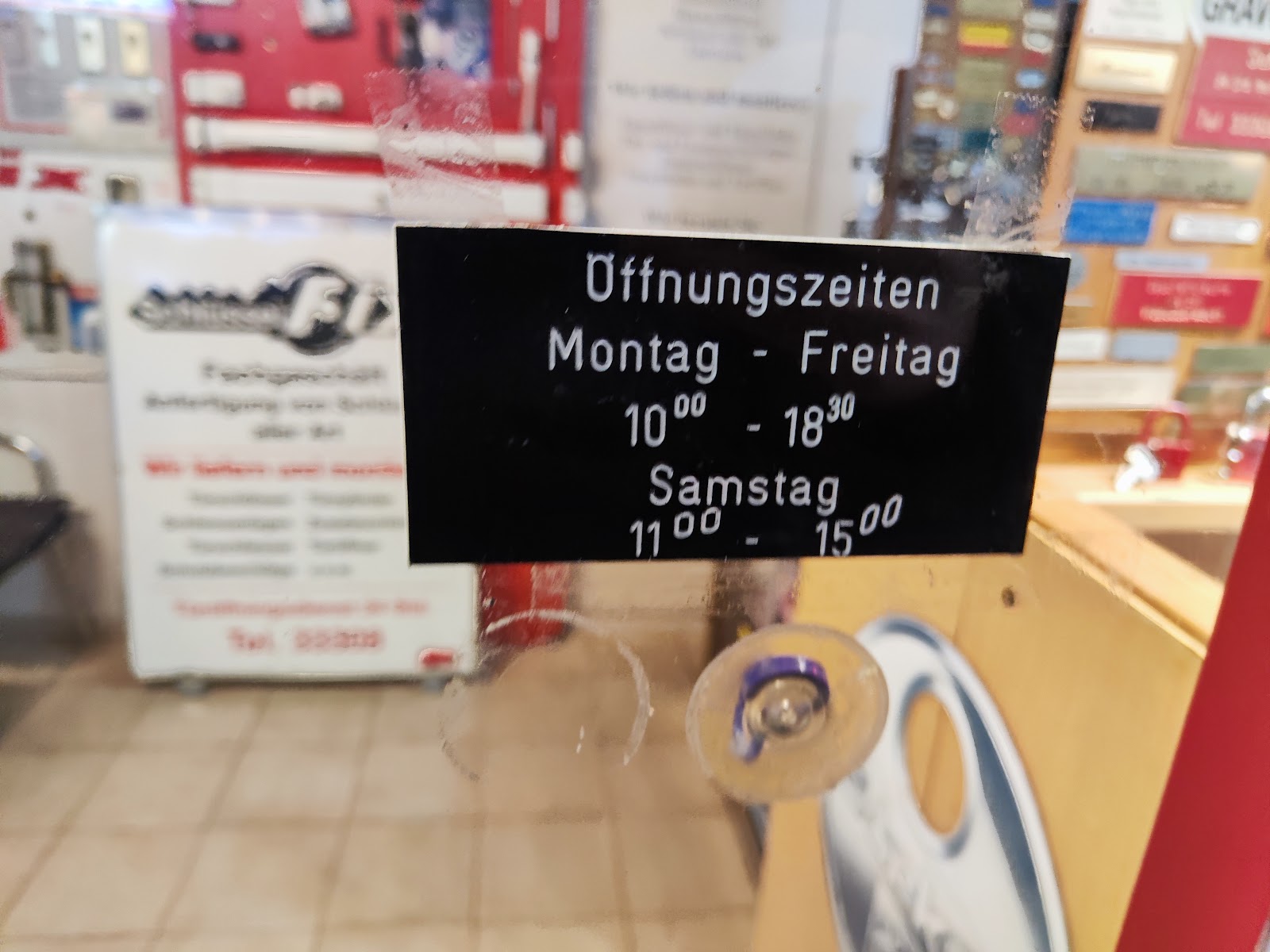 Öffnungszeiten-Aufkleber im Schaufenster von Schlüssel-Fix