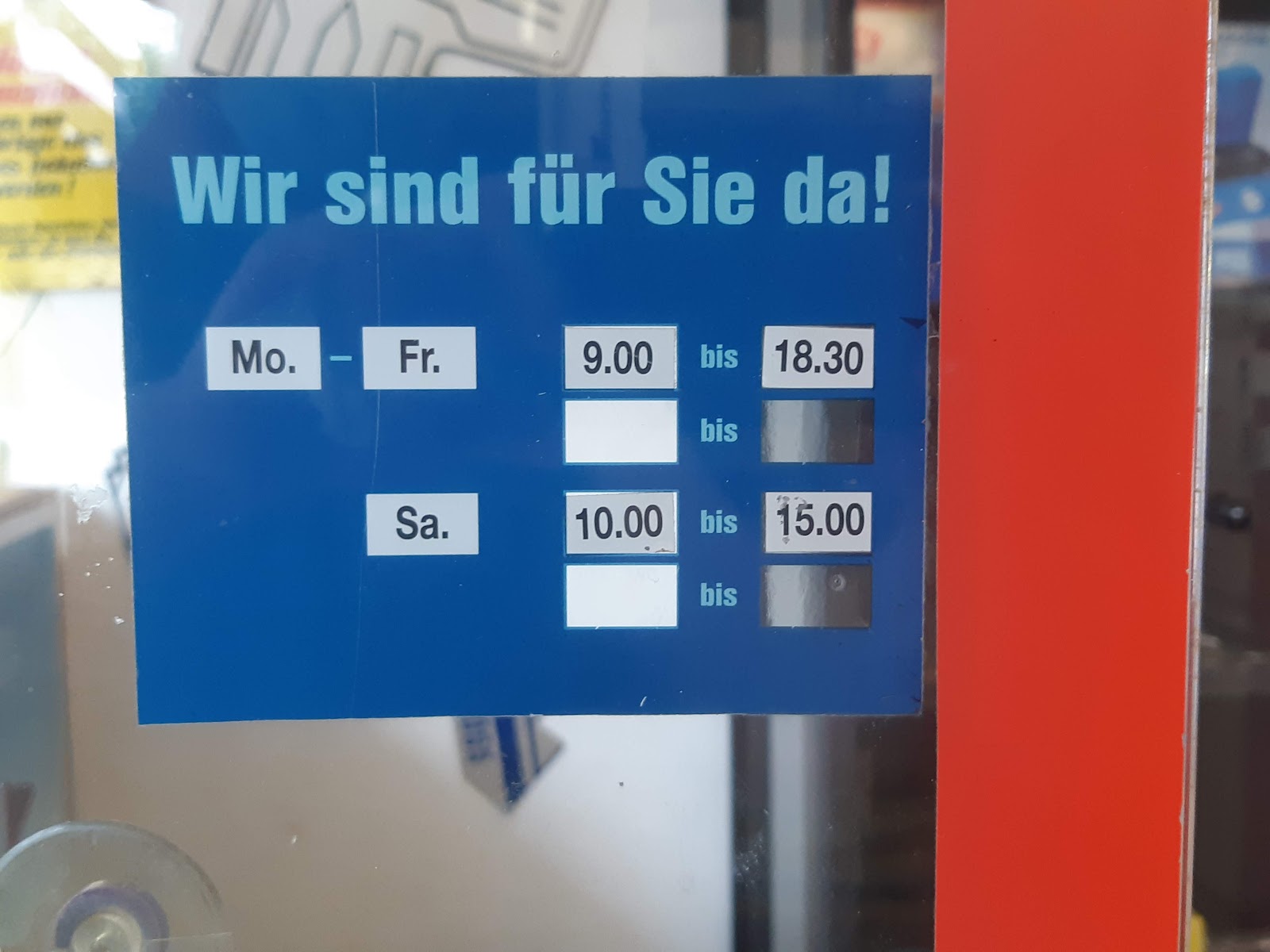 Hinweisschild "Wir sind für Sie da" im Schaufenster von Schlüssel-Fix